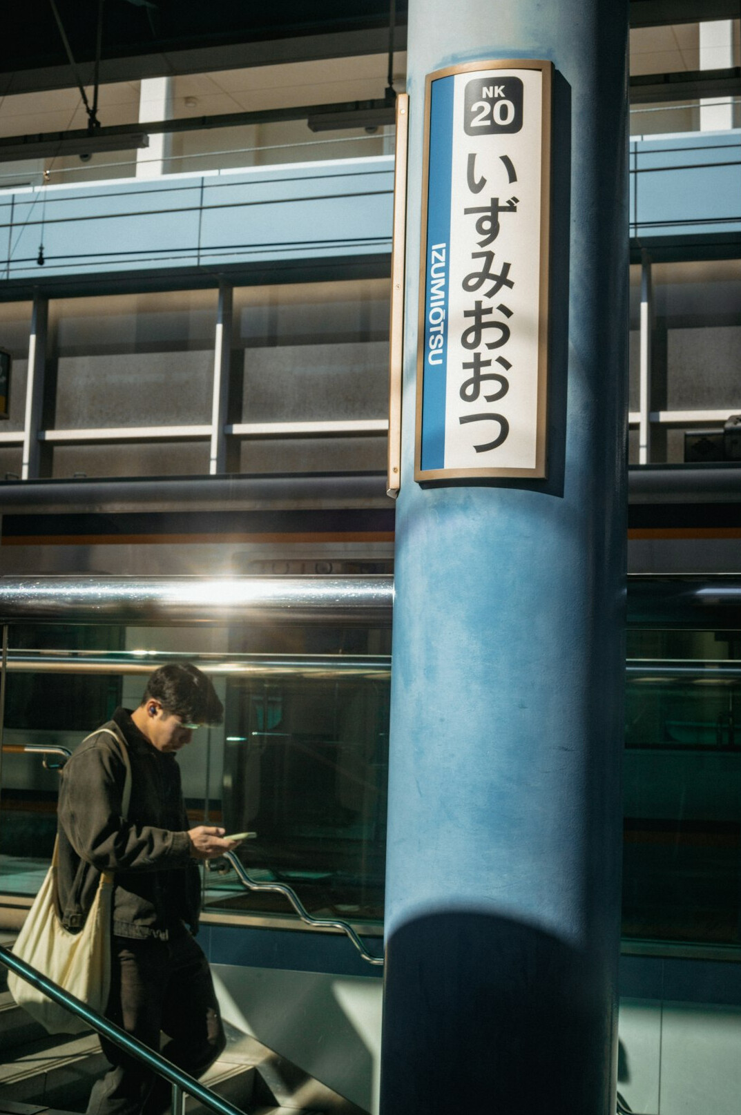 Older man checking a digital ticket on his phone at a train station